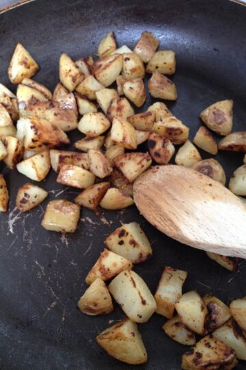 A recipe featuring sautéed potatoes cooked in a frying pan with garlic.