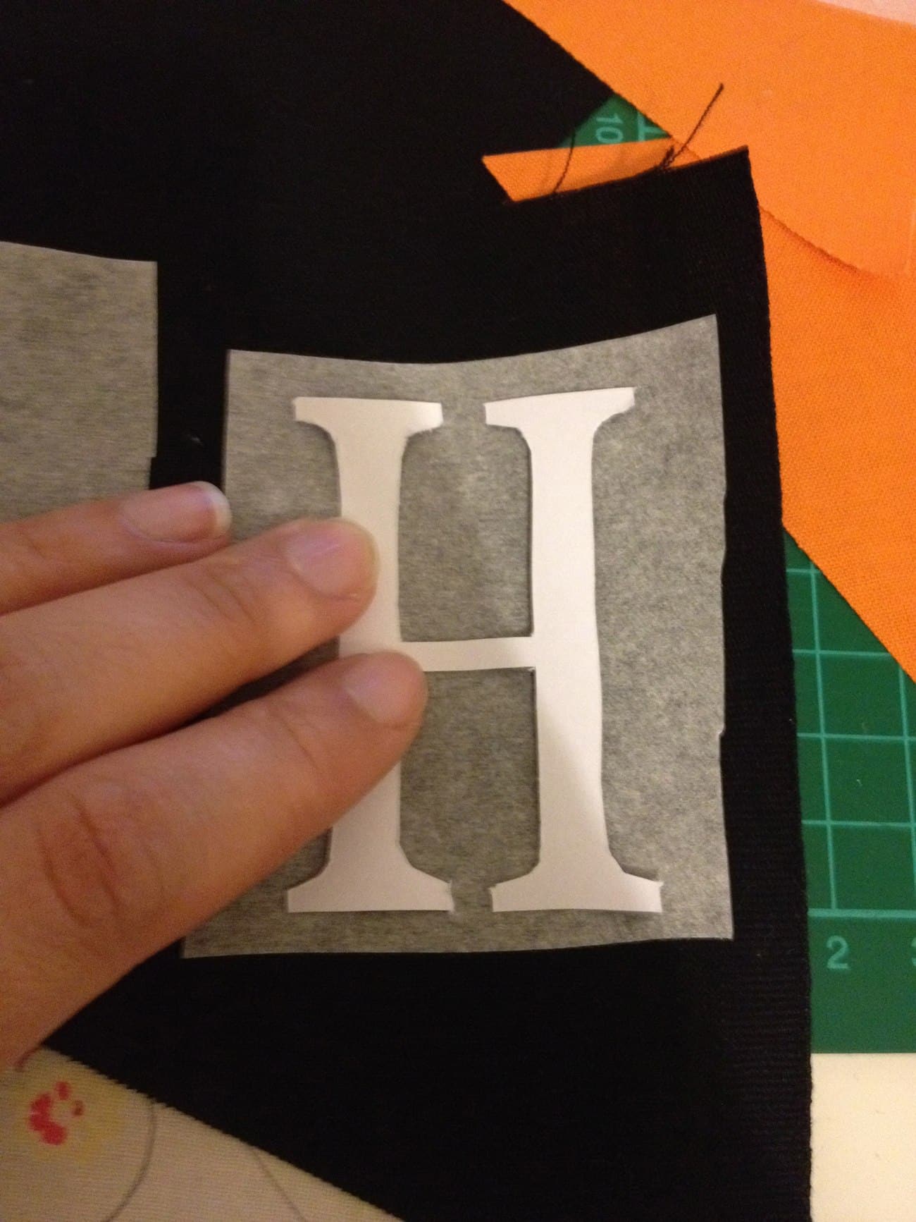 A Halloween enthusiast crafting a "h" shape on fabric, following a bunting tutorial.