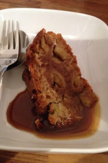 A homemade toffee apple cake on a plate with a fork.
