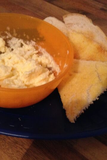 A table with a bowl of bread and scrambled egg.