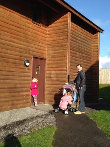 A man pushing a stroller in front of a house captured in 2013.