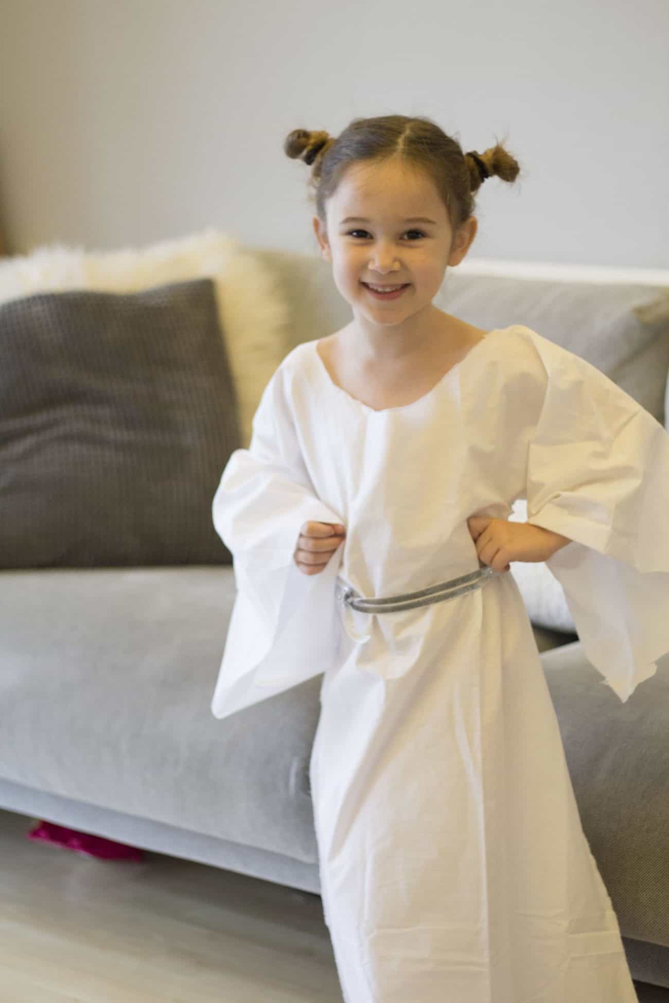 a girl dressed in a homemade princess leia costume - made out of a white bedsheet and silver ribbon - no sew tutorial.