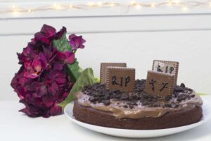 A chocolate cake with a tombstone on top.