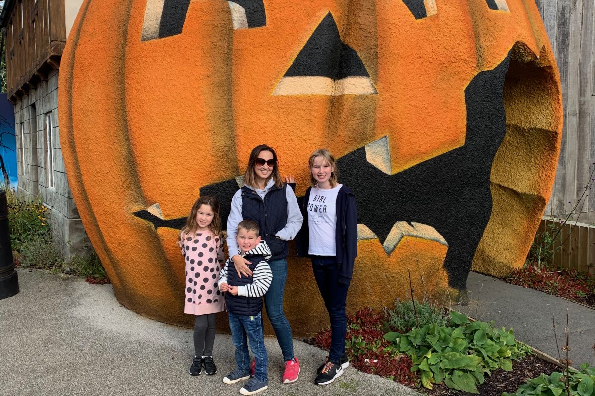 family standing by a giant pumpkin