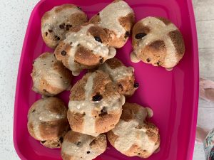 Hot cross buns on a pink plate, a delightful addition to our family diary amidst the coronavirus pandemic.