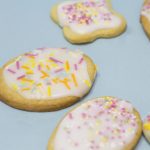 biscuits iced with white icing and decorated with sprinkles