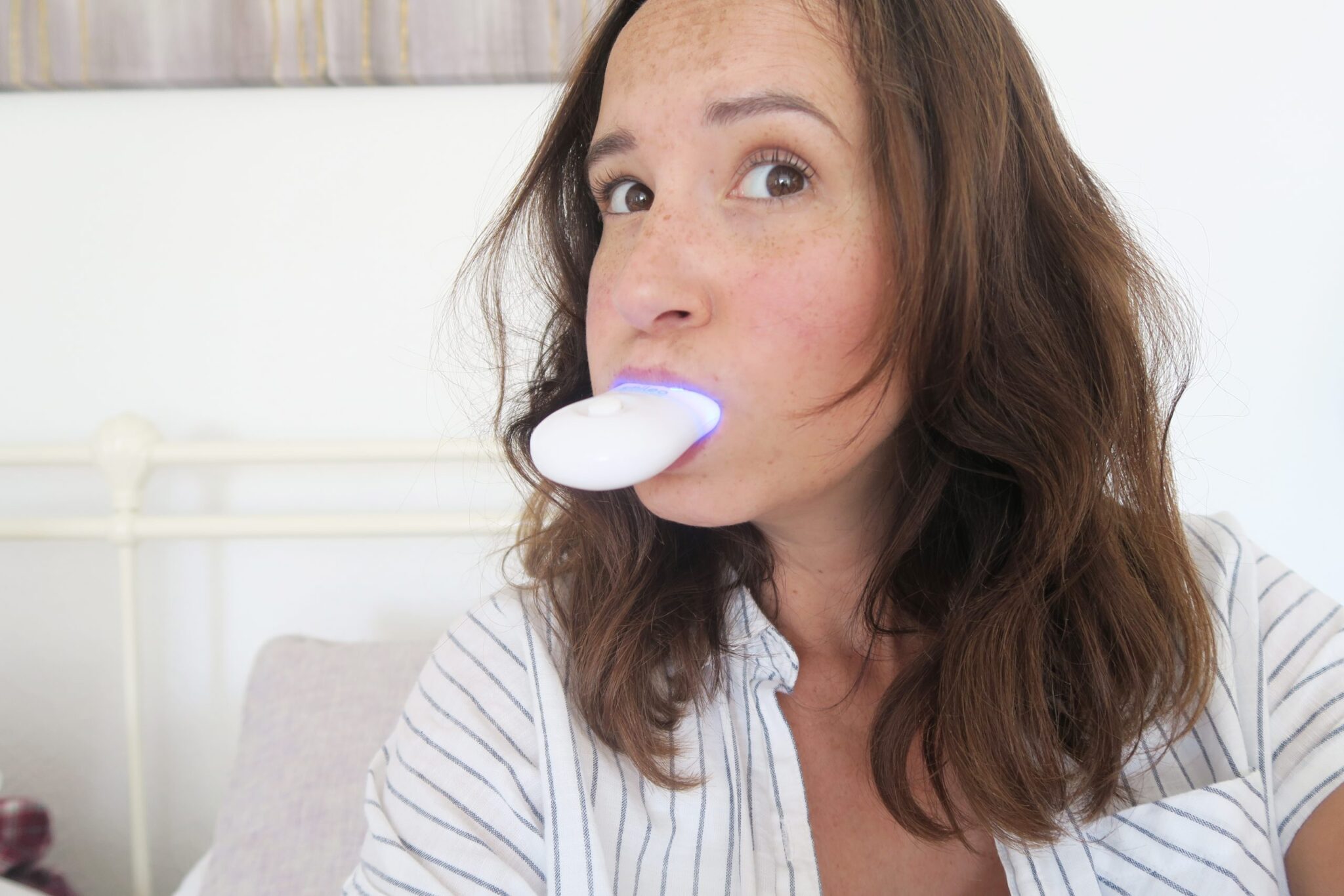 woman using a uv teeth whitening kit