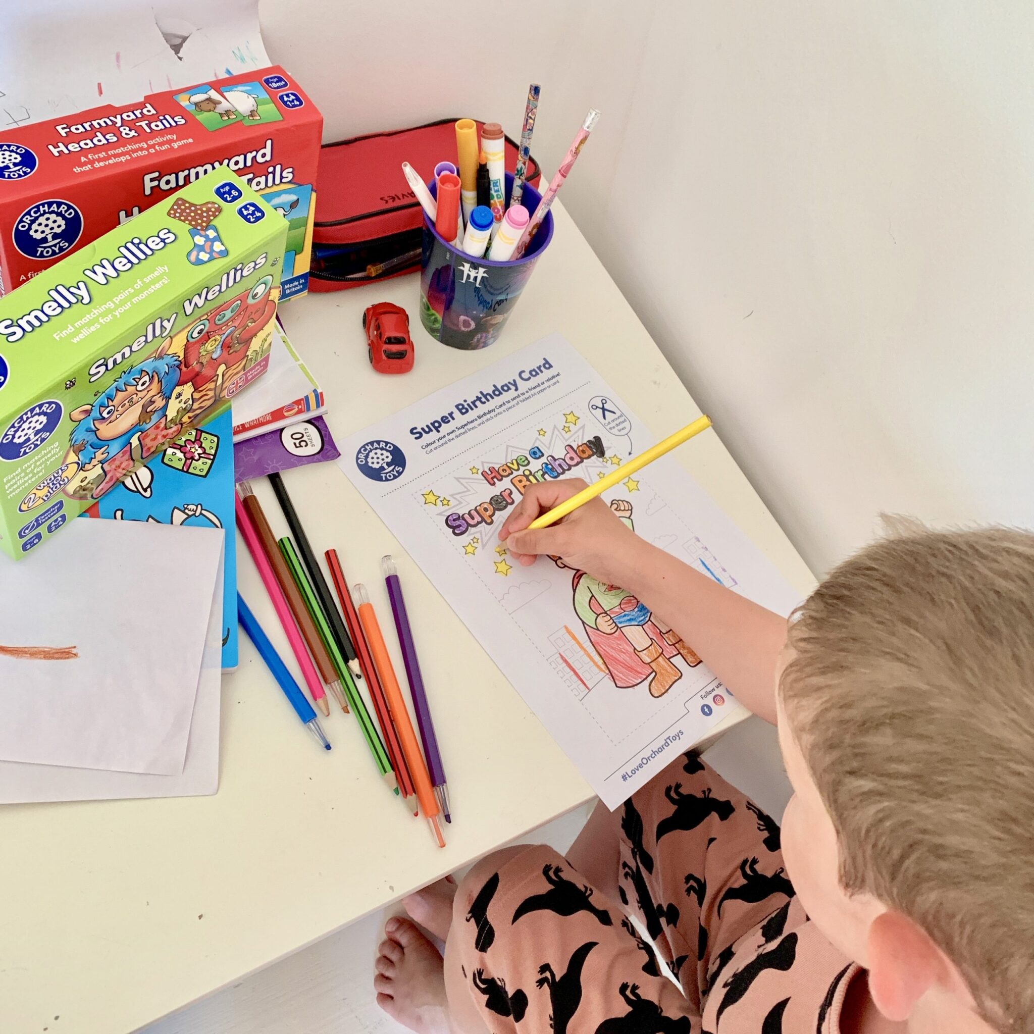 little boy sitting at a desk colouring