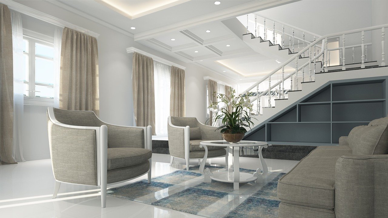 a large white room with big windows and two armchairs and a coffee table. Stairs in the background