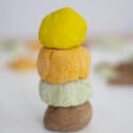 a stack of homemade playdough balls, yellow, orange, green and brown