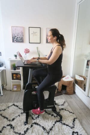 Woman using a Flexispot exercise desk while on a laptop
