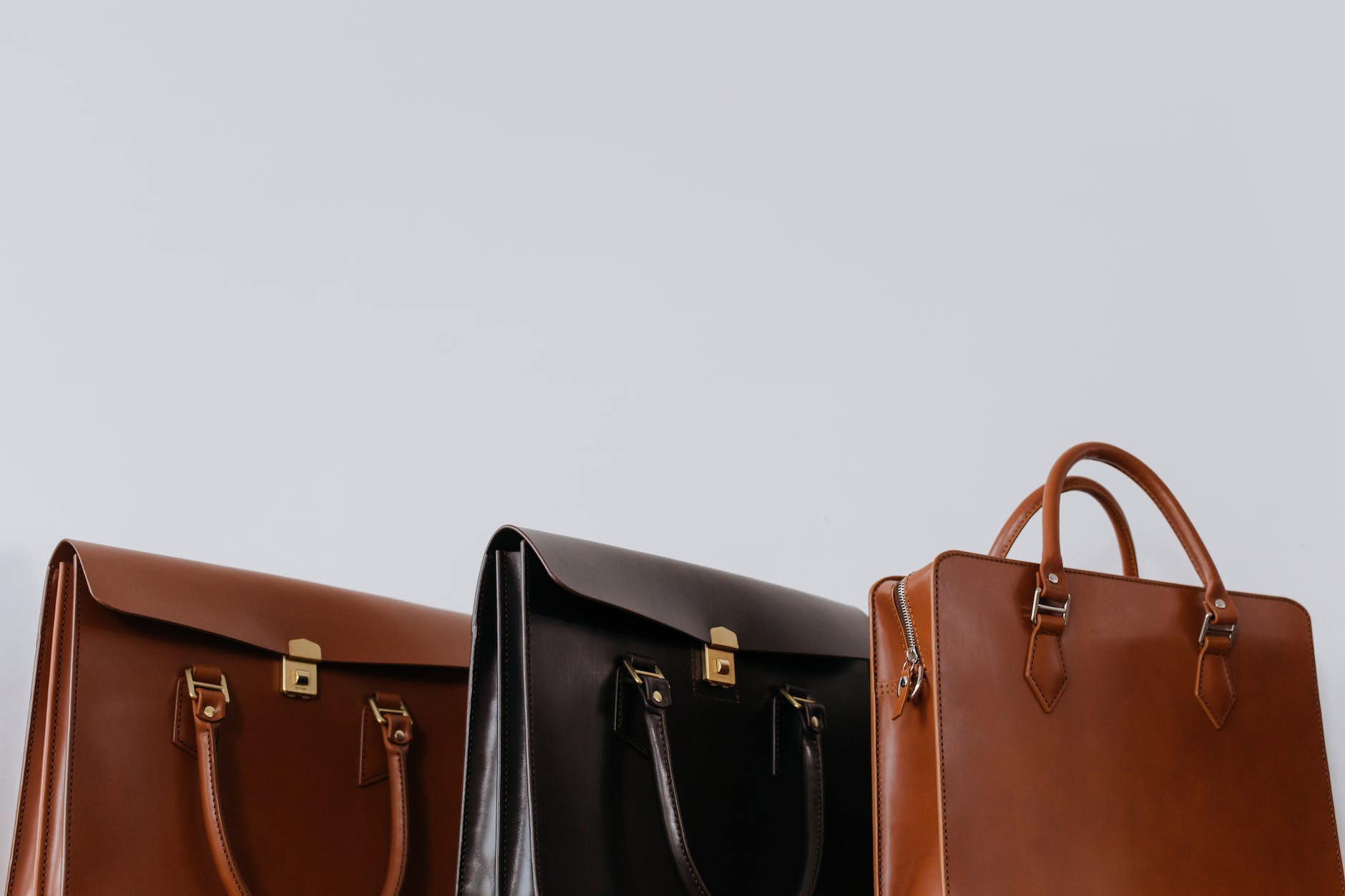 brown and black leather bags in close up photography