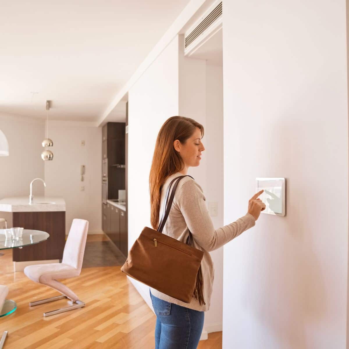 A woman looking at a smart thermostat in a living room, enhancing her home security for peace of mind.