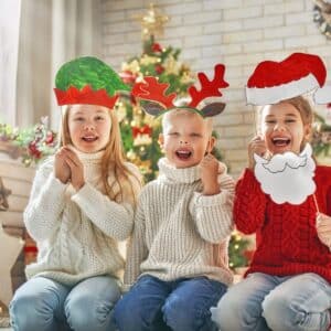 three kids holding up christmas hats