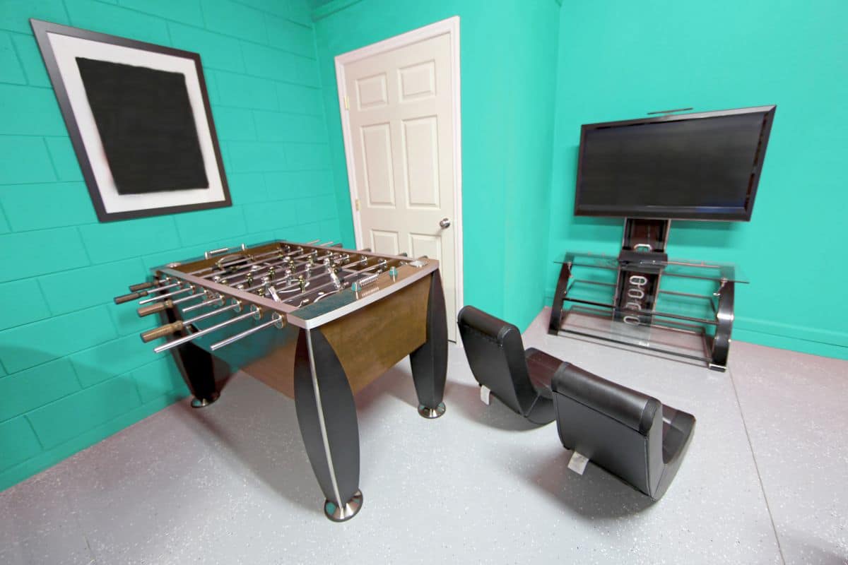 room with a football table and game station and chairs