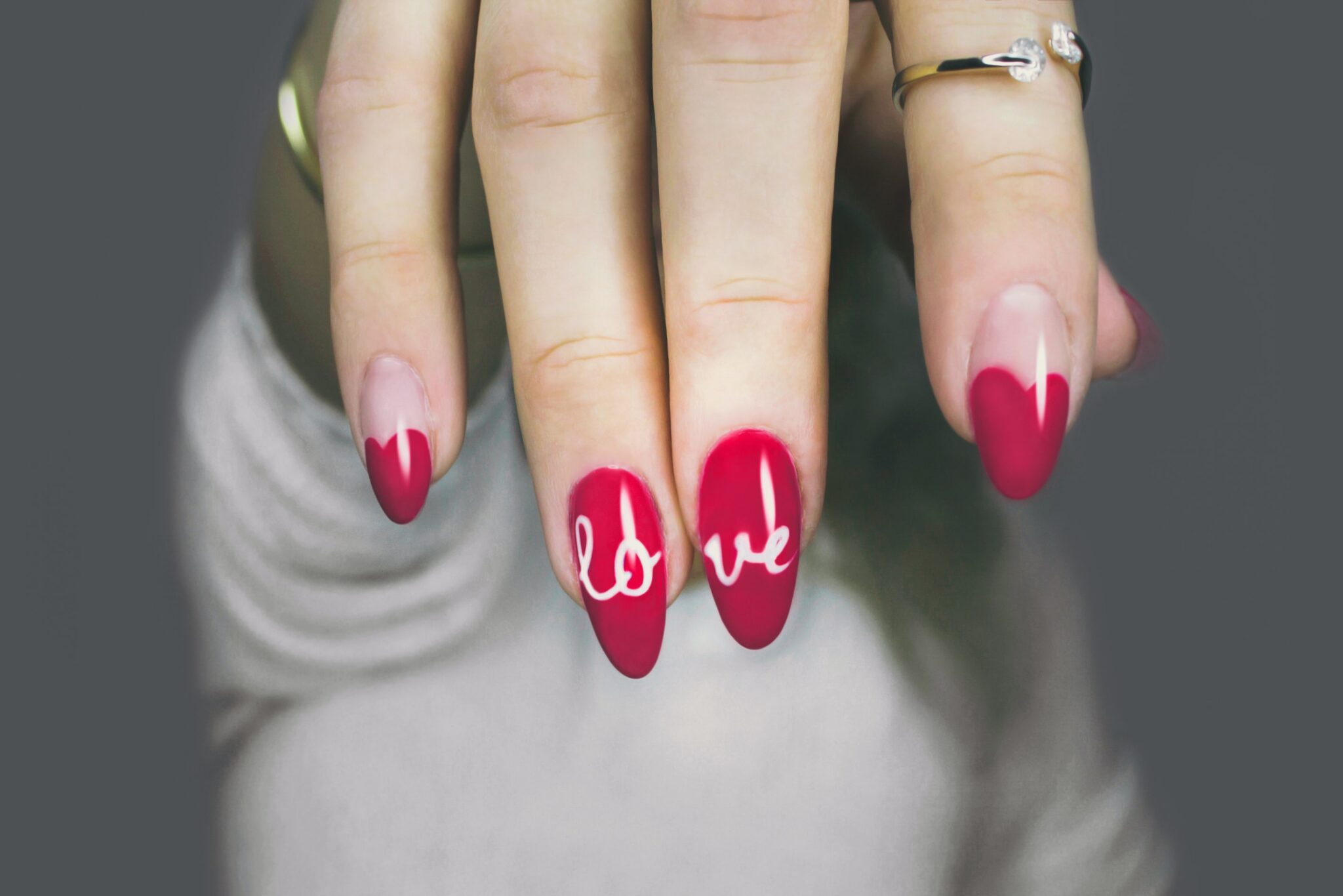 valentines love nails - red nails with love written across two of them in white varnish