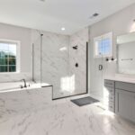 Modern bathroom with marble tiles, a walk-in shower, and a freestanding bathtub featuring the best flooring and underfloor heating.