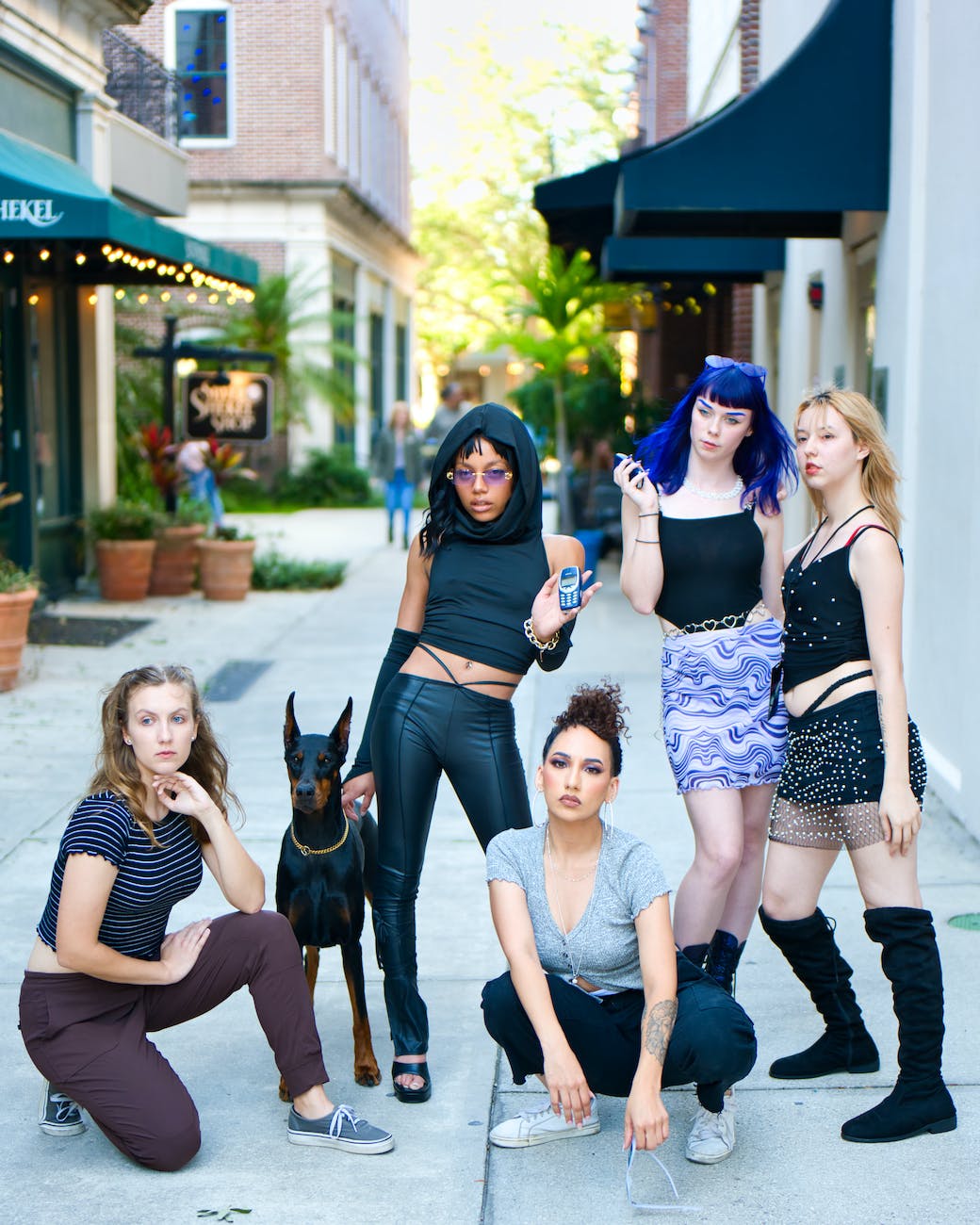 group of girls posing with dog on street