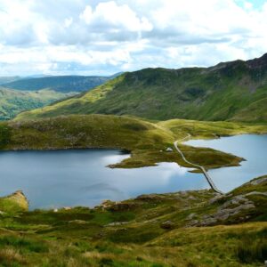 The Lake District, a family-friendly destination with a lake surrounded by grassy hills and mountains.