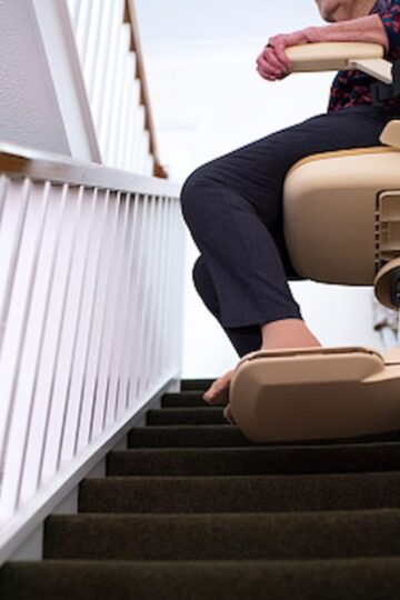 A person using a starlift to ascend a home staircase effortlessly, showcasing the affordable convenience it brings to daily life.