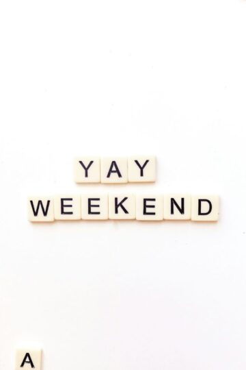 Tiles spelling "YAY WEEKEND" in the center on a white background, surrounded by scattered tiles at the edges, capturing the excitement of weekends and how you choose to spend your free time.