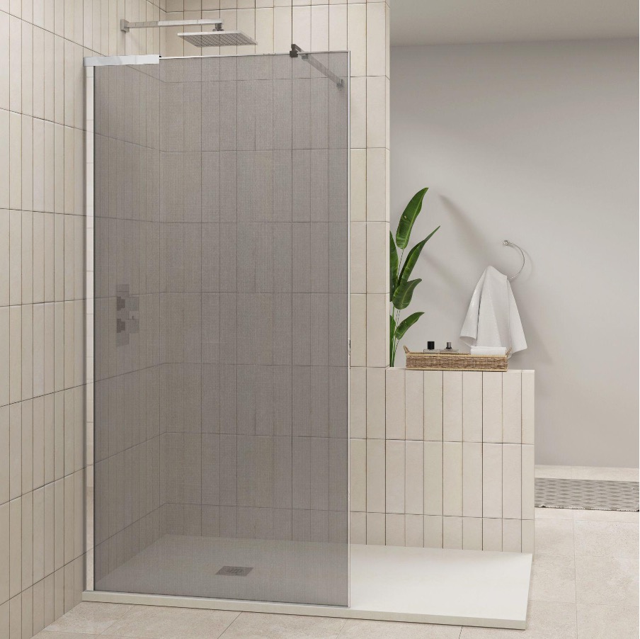A modern bathroom features a sleek shower enclosure with glass options, beautifully tiled walls, a touch of greenery in the plant, a towel on a hook, and toiletries neatly organized in a basket.