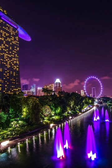 Night view of Singapore’s Marina Bay Sands hotel, with illuminated fountains, the city skyline, and Singapore Flyer in the background—ideal if you want to stay close to attractions. Perfect for those seeking expert travel advice or SG hotel booking tips.