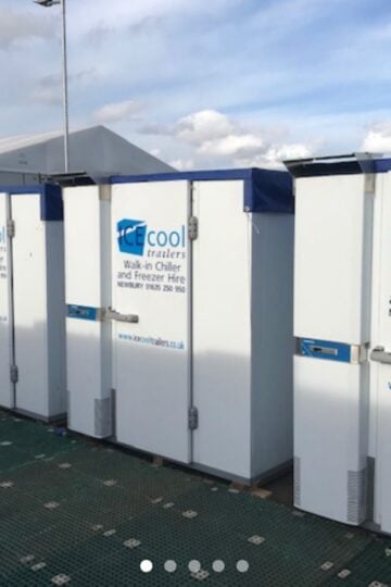 A row of mobile walk-in chiller and freezer trailers from ICE cool trailers, ideal for flexible freezer hire, parked outdoors on a patterned ground mat under a cloudy sky.
