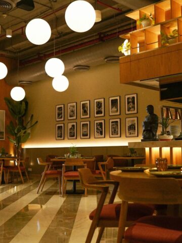 A room with tables and chairs and a statue, showcasing thoughtful restaurant design to enhance the overall restaurant atmosphere.