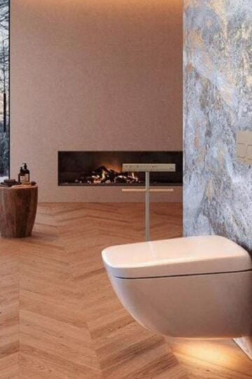 Modern bathroom with a wall-mounted toilet, bidets, freestanding bath, wood-patterned floor, stone feature wall, and a built-in fireplace—perfect to simplify family life with both style and comfort.