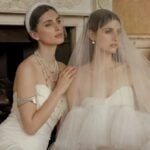 Two women in white strapless Missacc Wedding Dresses; one wears a pearl necklace and headband, the other has a veil over her face. Both are seated indoors, exuding quality that's truly worth your money as they look away from the camera.