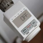 Close-up of an electronic thermostat display showing "OFF," with buttons labelled Mode, Menu, Boost, OK, and a sun icon-an essential tool for effective home heating.