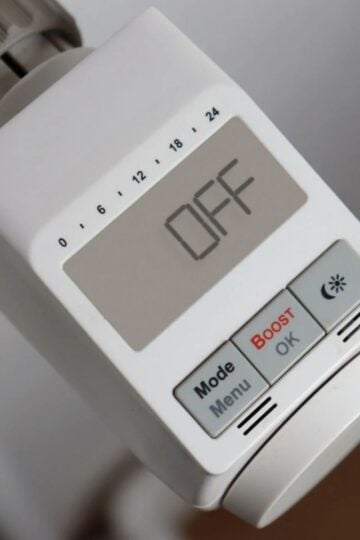 Close-up of an electronic thermostat display showing "OFF," with buttons labelled Mode, Menu, Boost, OK, and a sun icon—an essential tool for effective home heating.