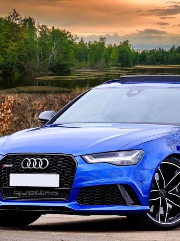 7 Practical Tips for Looking After Audi A3 Tyres A blue Audi sports car parked outdoors near a lake with trees and a sunset sky in the background, highlighting the importance of regular tyre maintenance for optimal performance, especially when driving an Audi A3 with high-quality tyres.