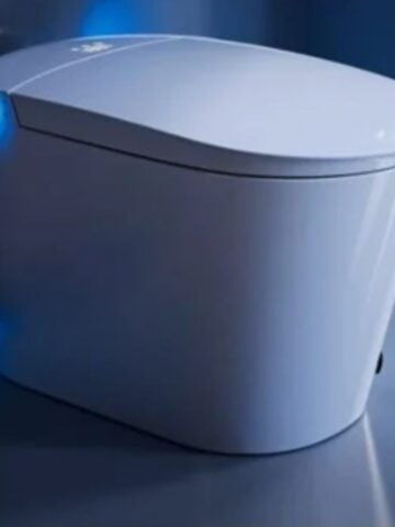 Creating a Comfortable Smart Bathroom: A Smart Toilet Buying Guide A modern, sleek white smart toilet with soft blue LED lighting, set against a glossy, minimalist bathroom wall-perfect inspiration for your smart bathroom or next toilet buying guide.