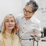 A healthcare professional examines a patient's ear using an otoscope in a medical surgery setting.
