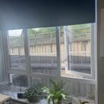 window tinting. A window with one pane open overlooks a concrete retaining wall and walkway; potted plants sit on the indoor windowsill, enhancing kerb appeal and offering inviting touches that support tenant retention.